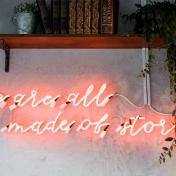 we are all made of stories quote pink glass neon sign