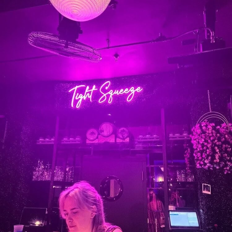 Establishment purple led neon sign on green wall